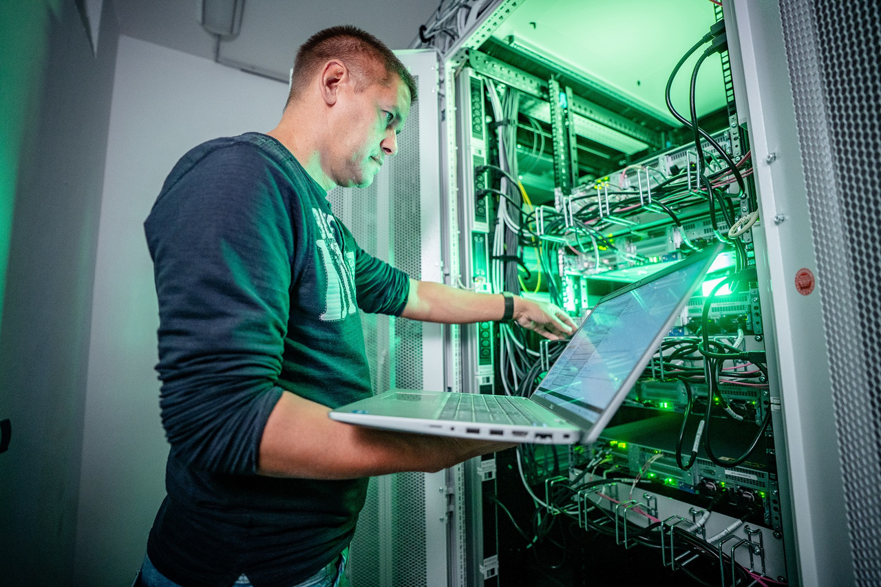 Ein IT Mitarbeiter an einem Serverschrank
