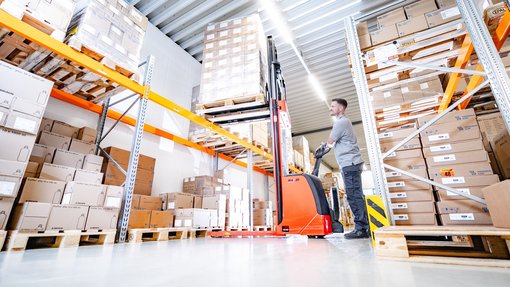 Lager und Logistik Ein Mitarbeiter der Logistik mit einer "Ameise" bei der Arbeit im Lager