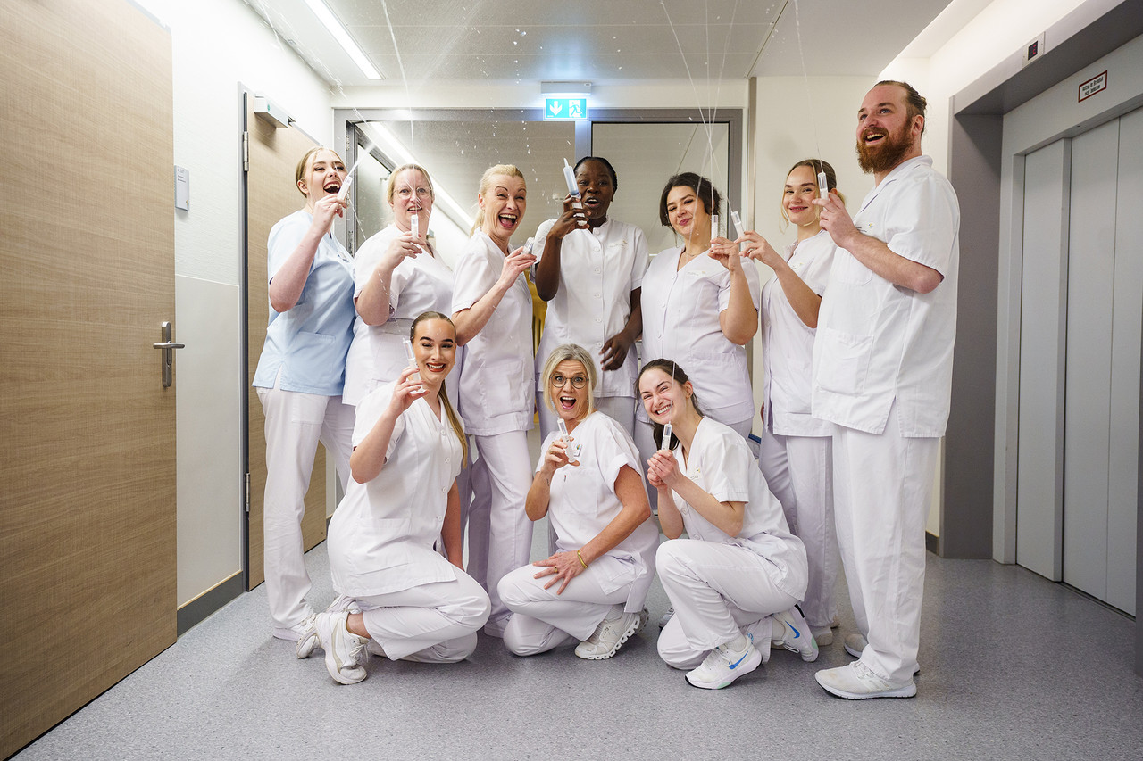Gruppenfoto frisch examinierter Pflegefachkräfte die mit Spritzen Wasser spritzen