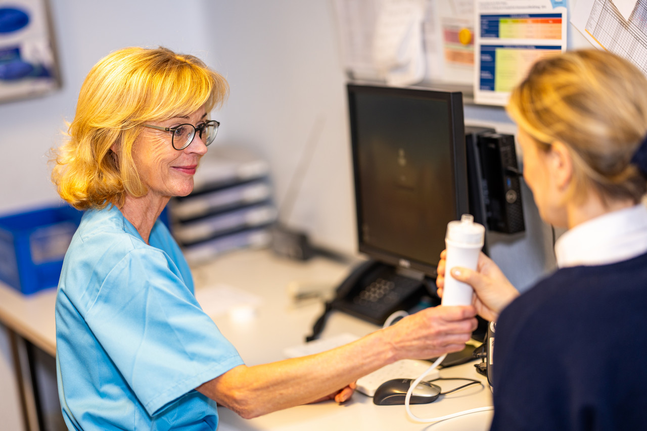 Eine MFA bei der Arbeit mit einer Patientin