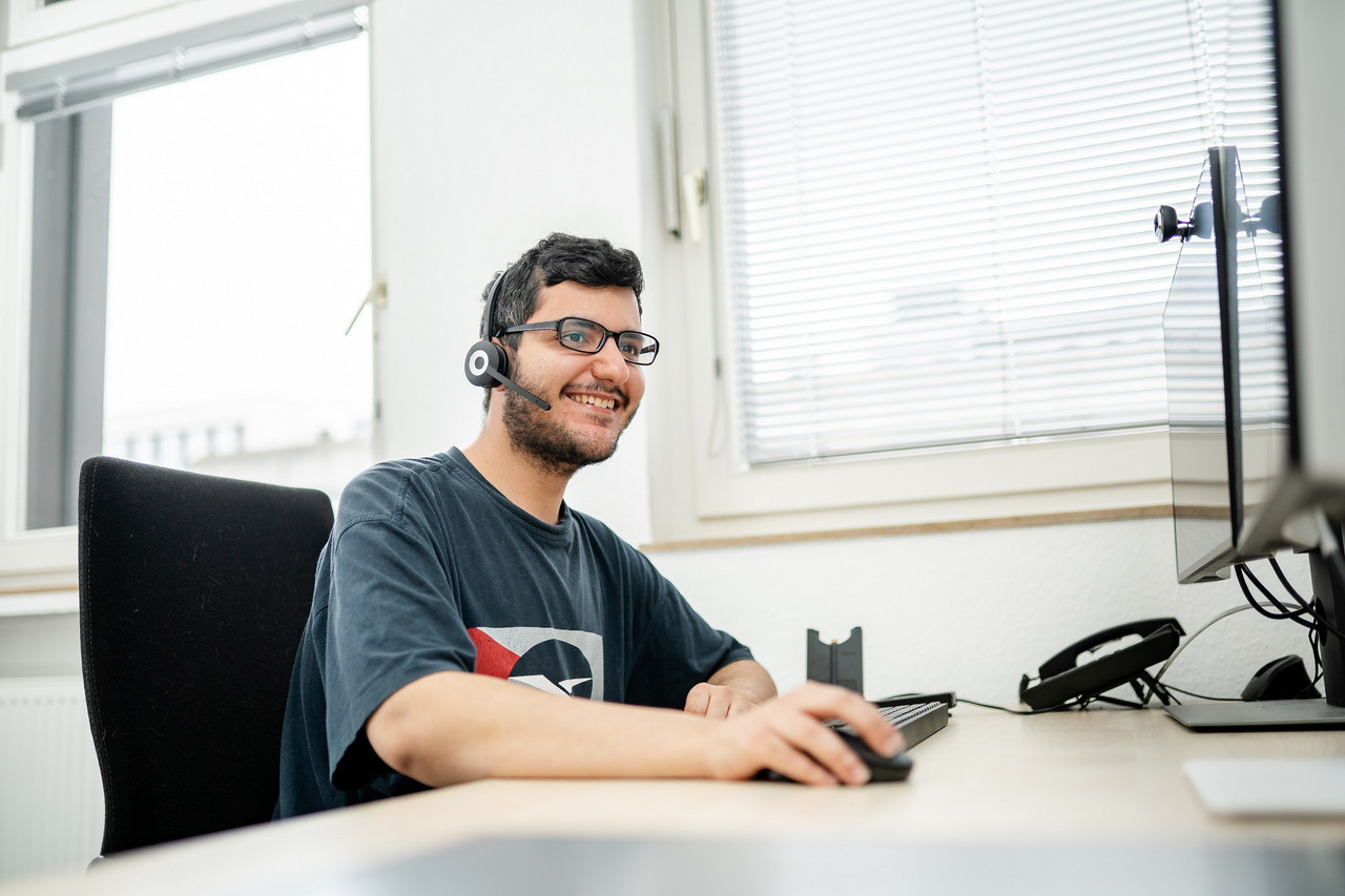 Ein Mitarbeiter der IT sitzt am Helpdesk