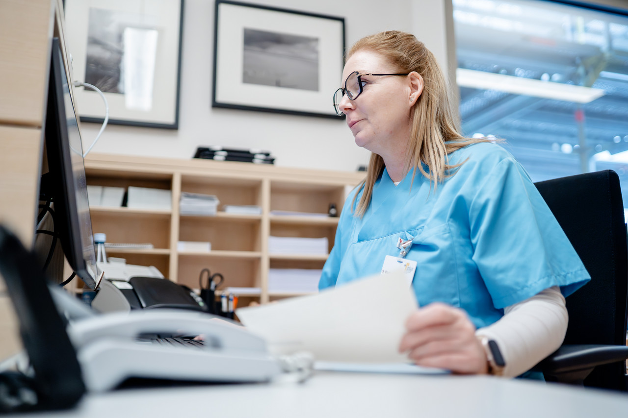 Eine MFA sitzt am Schreibtisch und blick zum Monitor