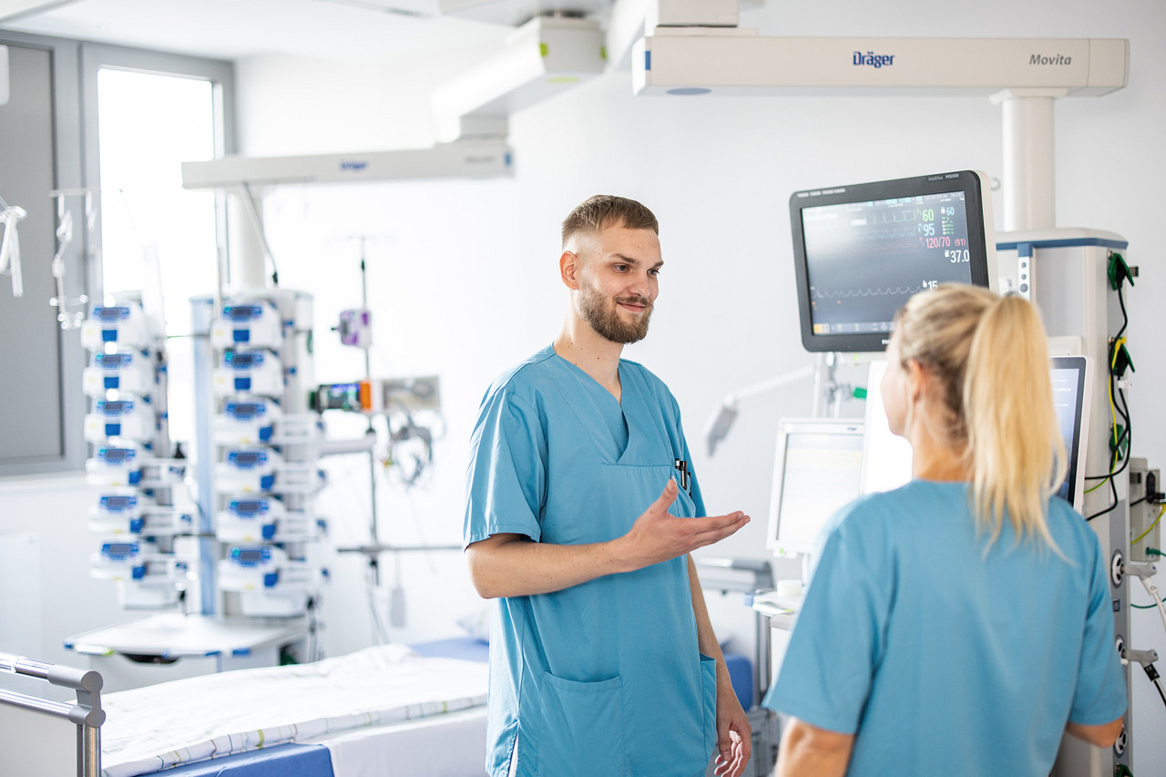 Zwei Pflegefachkräfte tauschen sich im Gespräch miteinander aus. Zwei Pflegefachkräfte tauschen sich im Gespräch miteinander aus.