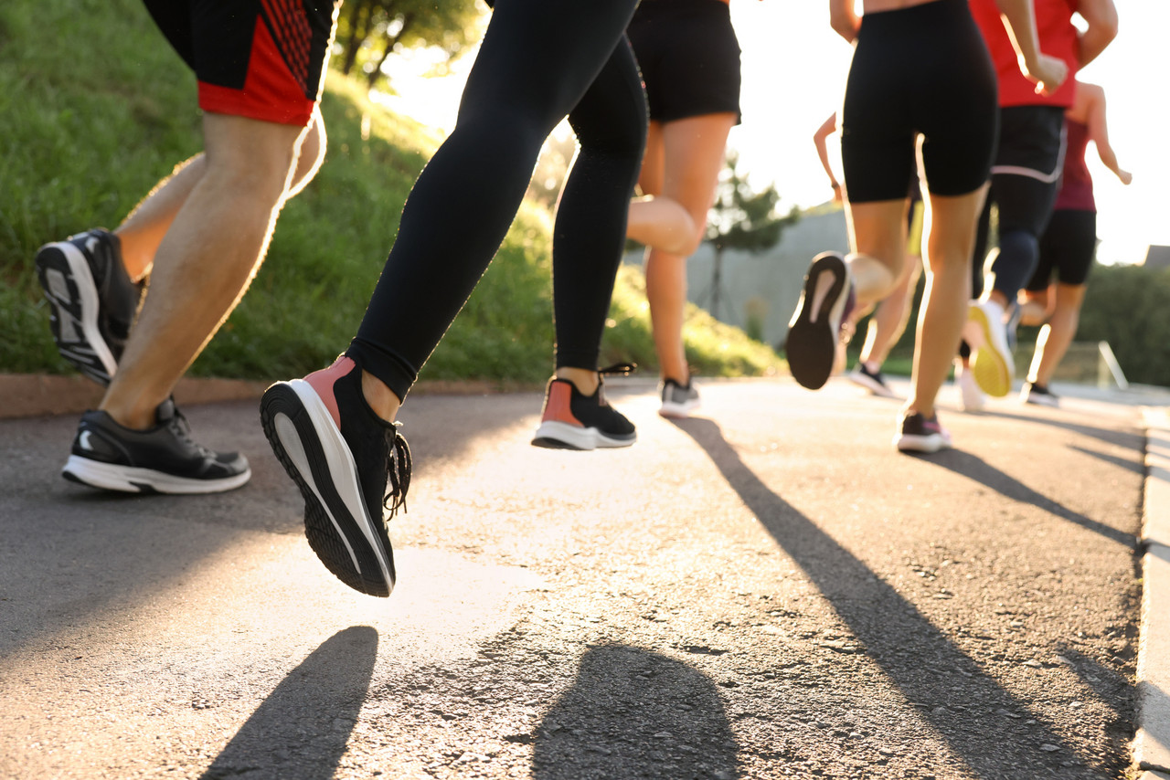Sport und Bewegung Laufszene mit mehreren Personen von hinten aus der Bodenperspektive im Freien